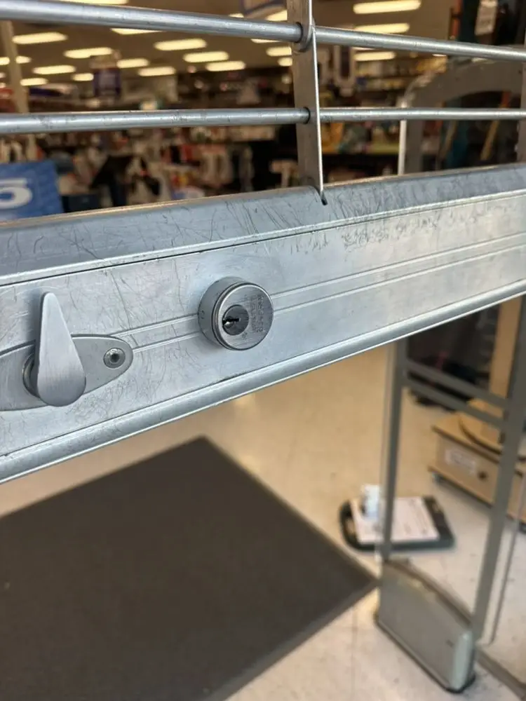 Lock mechanism on a security gate, showing keyhole and latch.