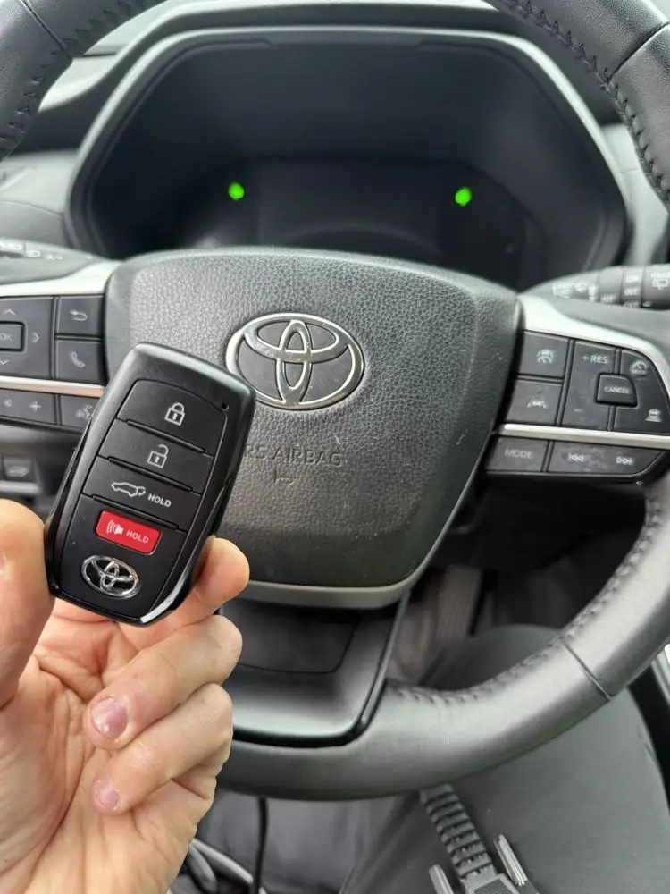 Car key fob for Toyota with lock and unlock buttons, held in hand.